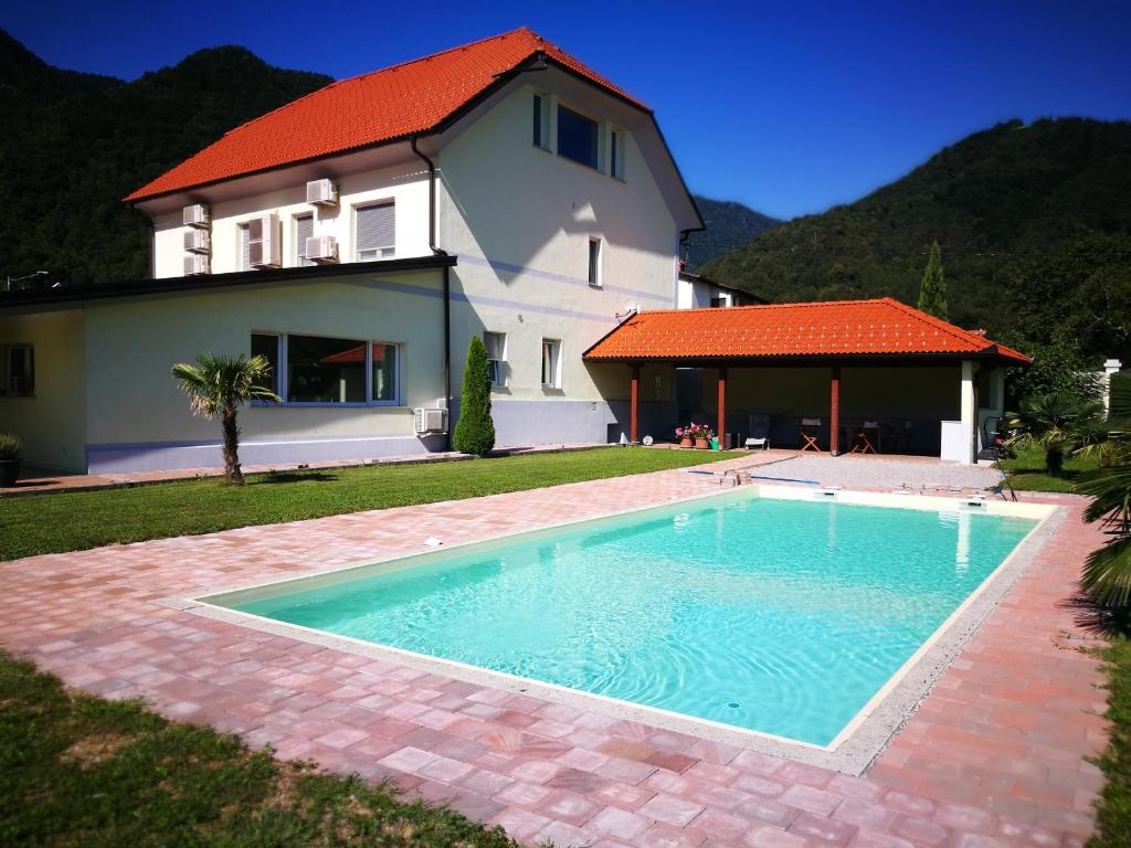 a swimming pool in front of a house at Apartments Volče in Tolmin