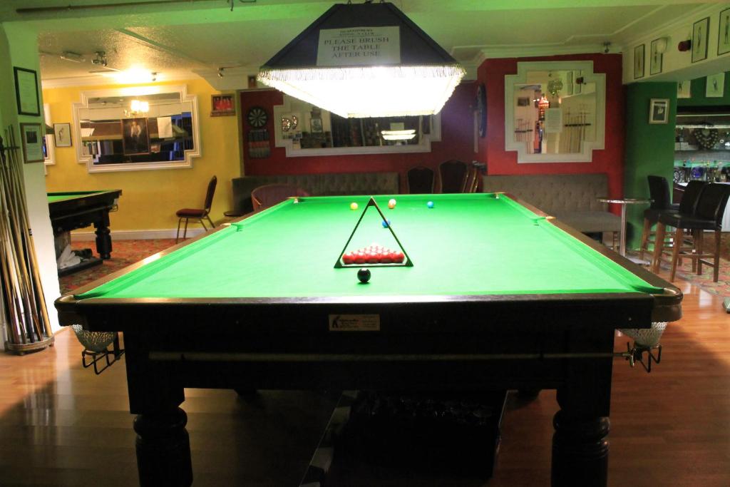 a pool table in a room with a poolhibitionhibitionhibition at Glastonbury Hotel in Eastbourne