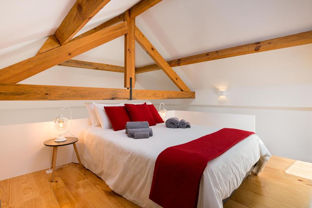 a bedroom with a large bed with red pillows at Almada Studio 419 in Porto