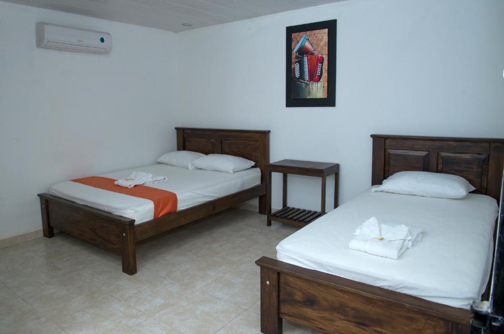 Postel nebo postele na pokoji v ubytování Aparta Hotel El Cacique Upar