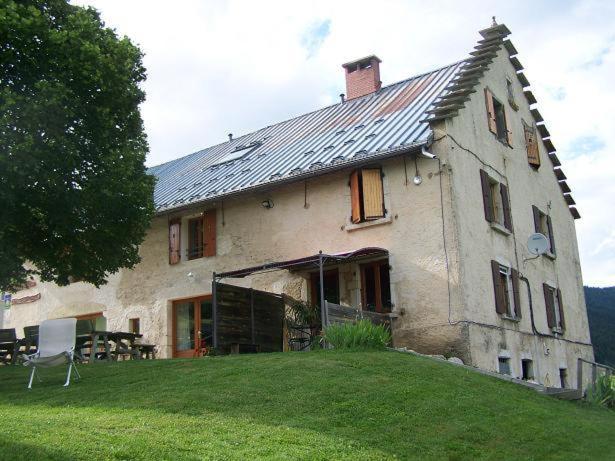 an old house with a roof on top of a yard at Le Gîte de l'Ourserie in Méaudre