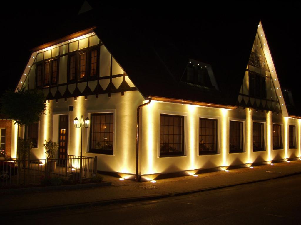 a building with lights on the side of it at night at Hotel Grasberger Hof GmbH in Grasberg