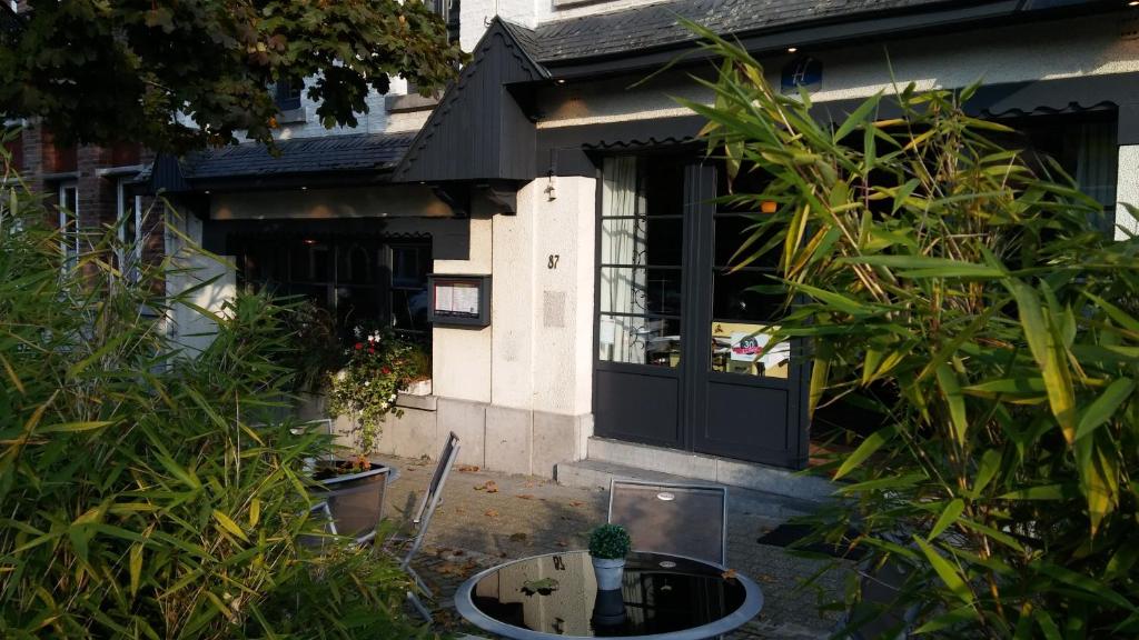 a house with a black door and some plants at Hotel La Fayette in Rochefort