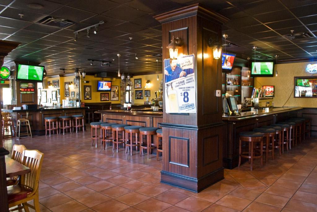 a bar with bar stools in a restaurant at Lake Buena Vista Resort Village and Spa, Near Disney in Orlando