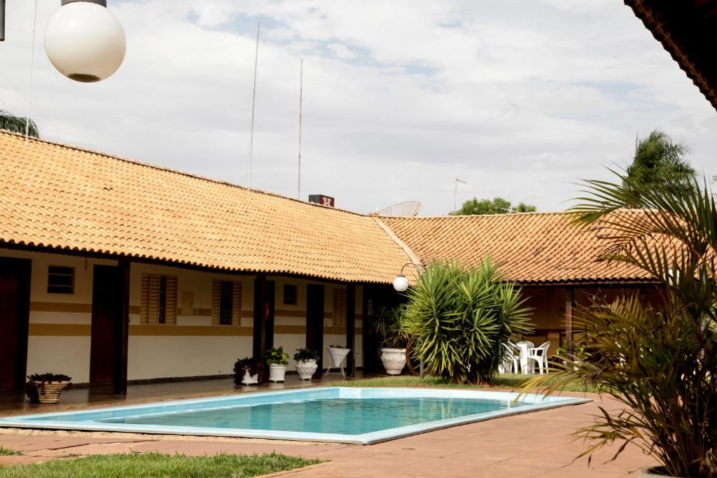a resort with a swimming pool in front of a building at Hotel Santa Fé in Santa Fé do Sul