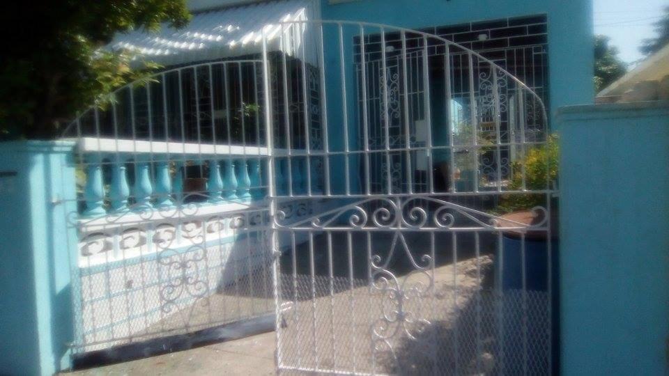 a gate in front of a blue building at Robby's Place in Harbour View