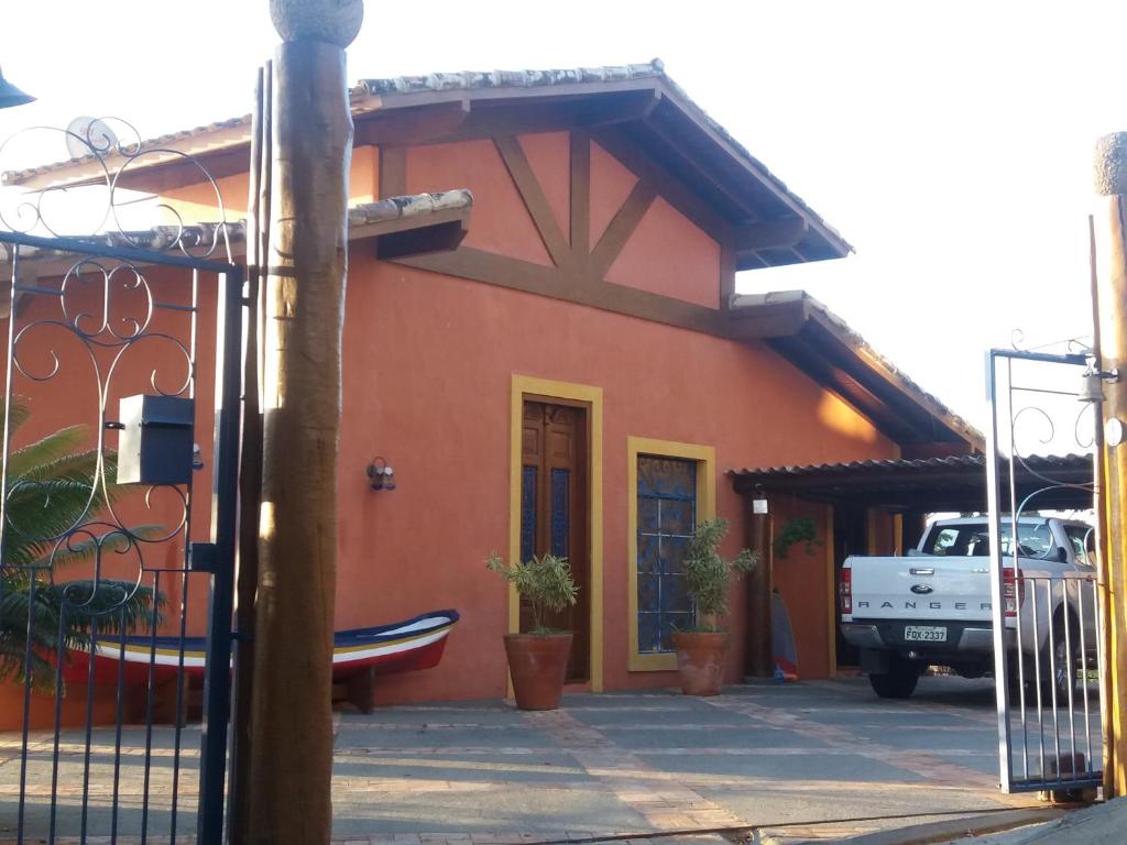 a red house with a truck parked in front of it at Suites Vista do Baepi in Ilhabela