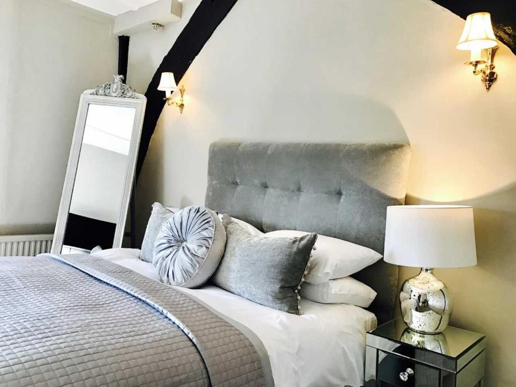 a hotel room with a bed and a lamp at The Star And Eagle Hotel in Goudhurst
