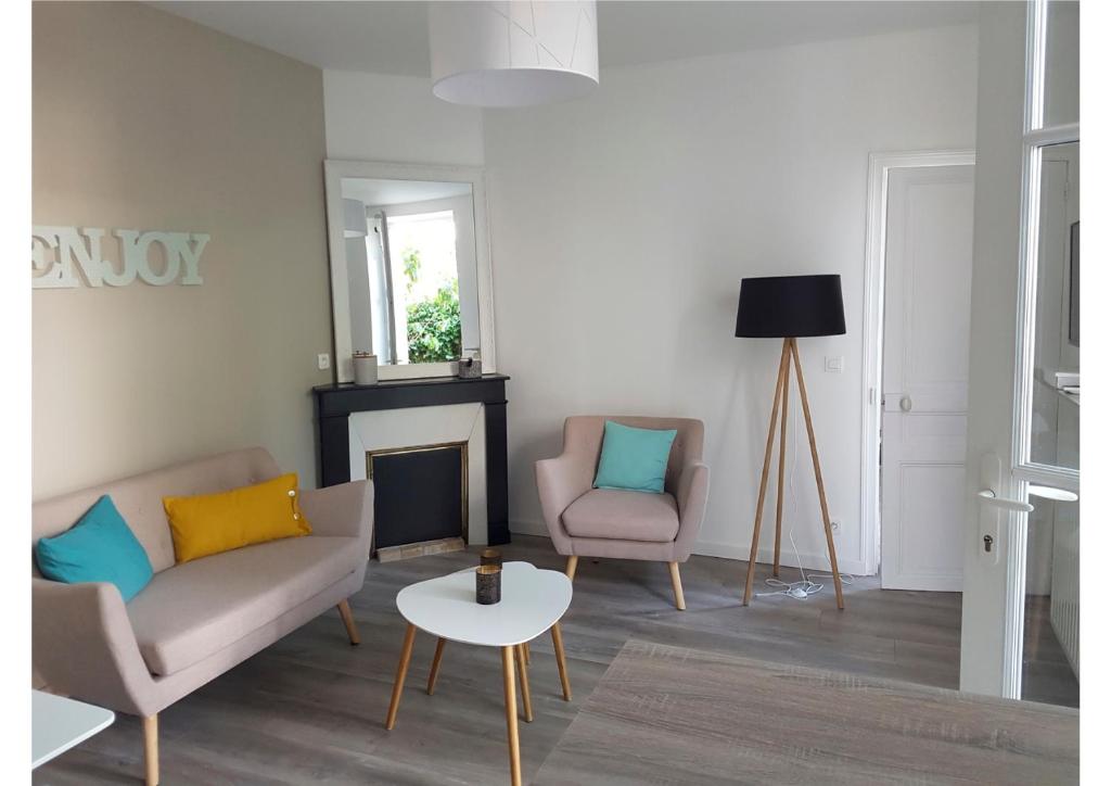 un salon avec deux chaises et une cheminée dans l'établissement Fontainebleau Sweet Home Garden, à Fontainebleau