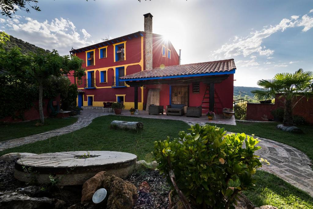 una casa colorida con un jardín delante en Valle Del Río Piedra en Carenas