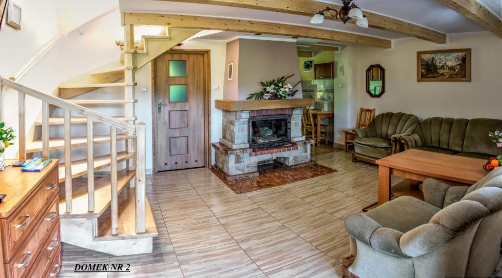 a living room with a fireplace and a staircase at Domki i Pokoje u Borsa in Lesko