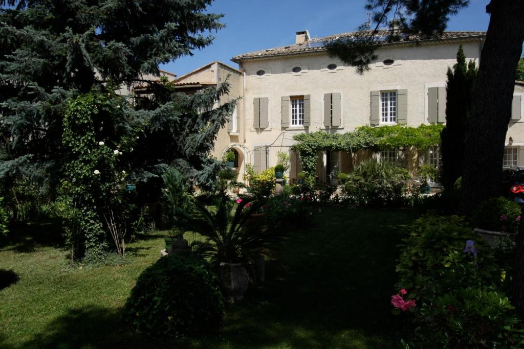 an old house with a garden in front of it at Mas Alpilles Soleil in Saint-Rémy-de-Provence