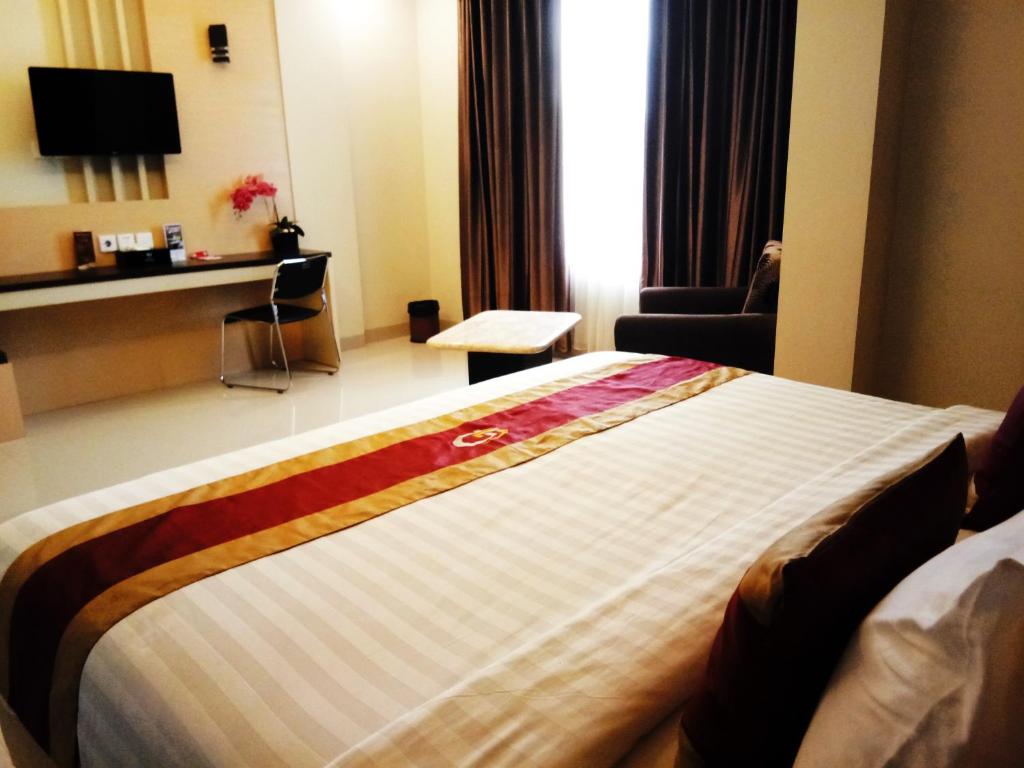 Postel nebo postele na pokoji v ubytování Grand Parama Hotel