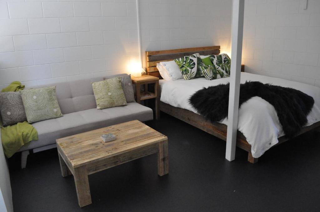 Millaa MillaaにあるThe Jungle Staysのベッドルーム1室(ベッド1台、ソファ、テーブル付)