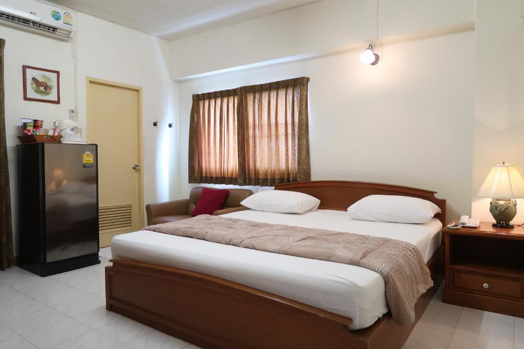 a bedroom with a large bed and a television at Phawana Sweet Hotel in Bangkok