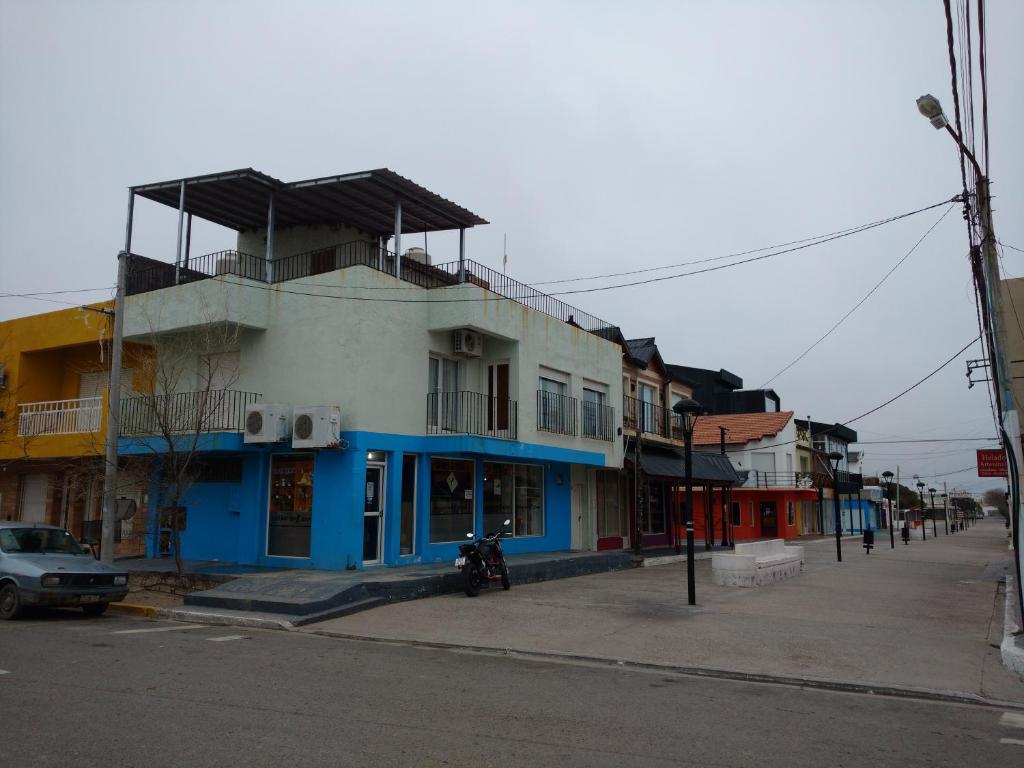 un edificio azul y blanco al lado de una calle en Departamentos Chiquina en Las Grutas