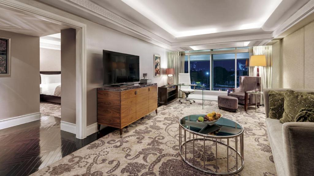a living room with a couch and a television at Hotel Indonesia Kempinski Jakarta in Jakarta