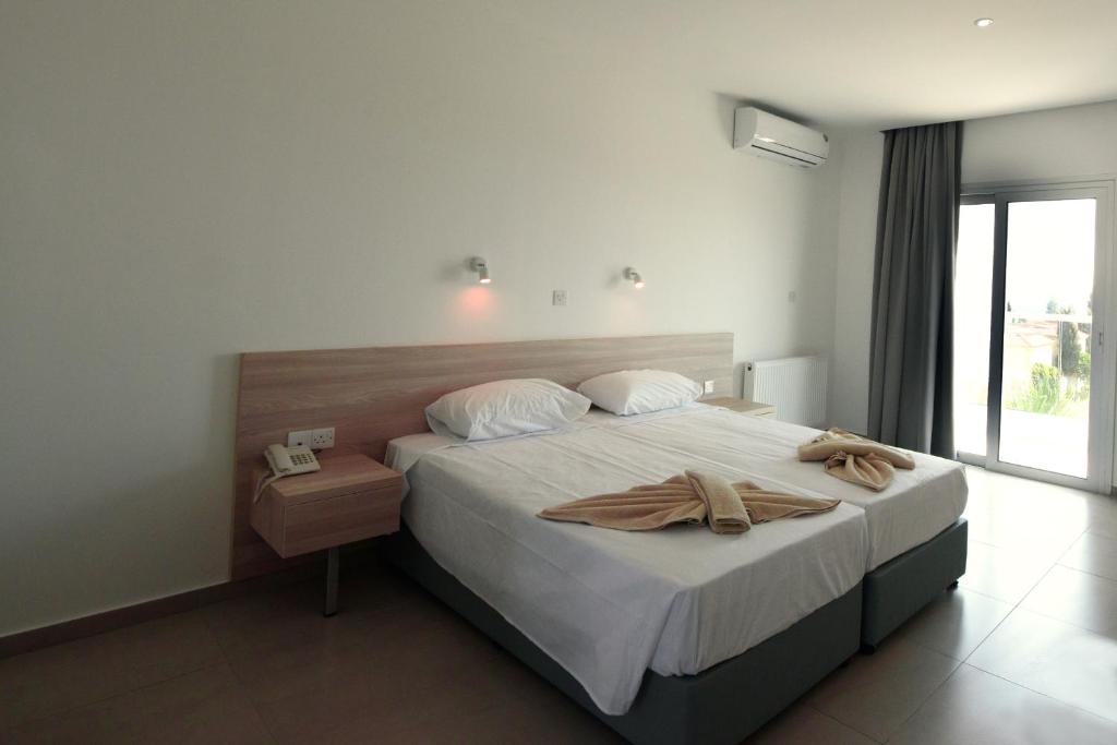 a bedroom with a bed with two towels on it at Evabelle Napa Hotel Apartments in Ayia Napa