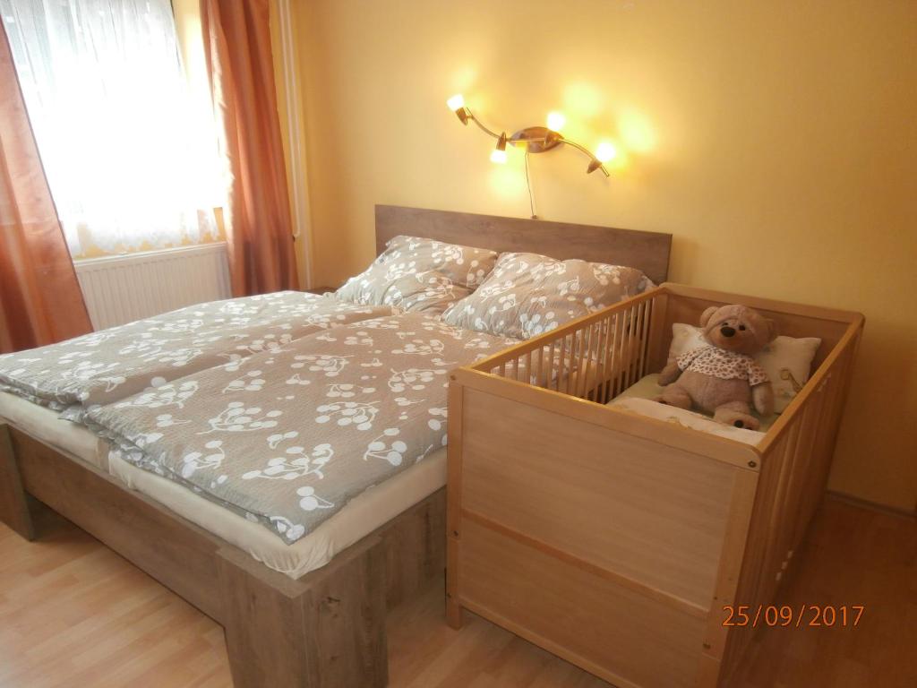 a small bed with a teddy bear sitting in it at Apartman Aya in Janov nad Nisou