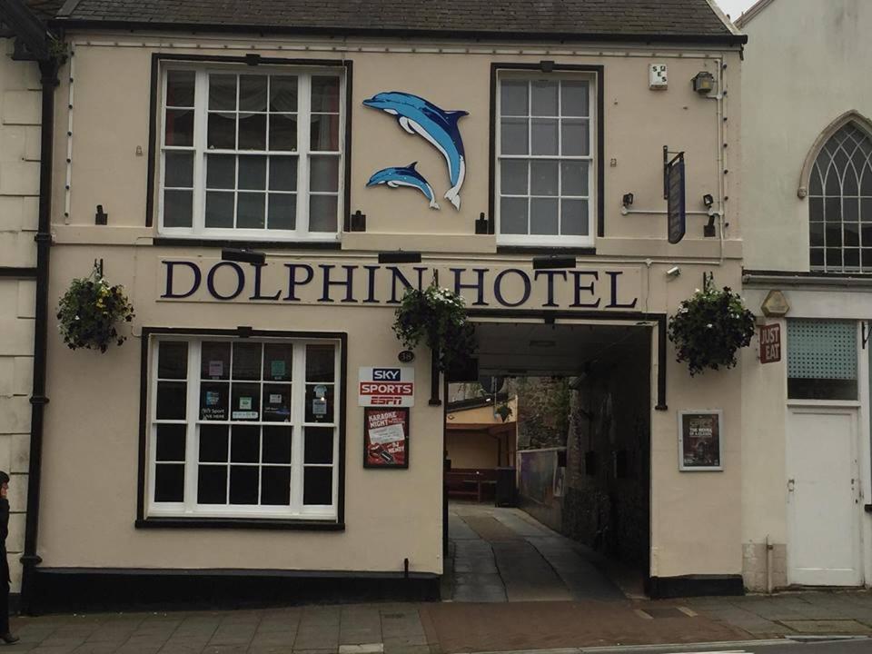 un hôtel de dauphins avec un panneau sur le côté d'un bâtiment dans l'établissement The Dolphin Hotel, à Chard