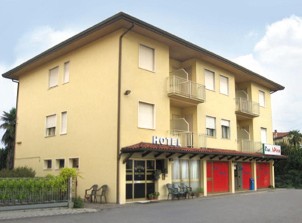 ノアーレにあるAl Bersagliereの赤いドアとホテルのある大きな黄色の建物