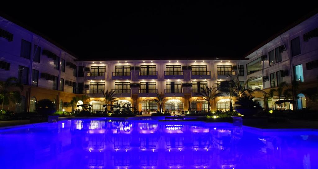 Hotel Oazis في بوتوان: مبنى أمامه مسبح في الليل
