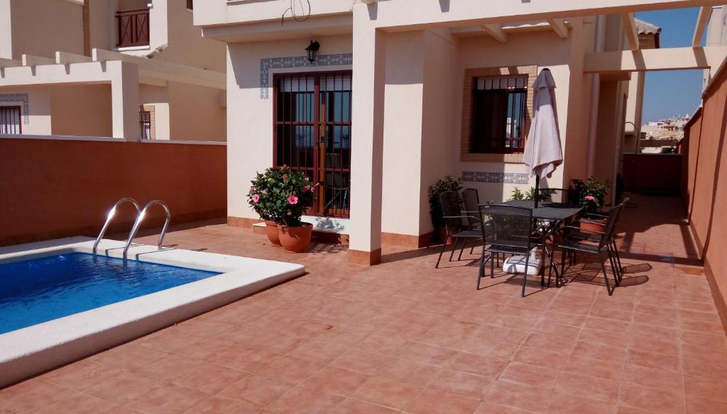a house with a swimming pool and a table and chairs at Casa Anna in Puerto de Mazarrón