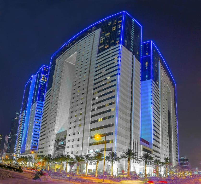 un grande edificio con luci blu di notte di Ezdan Hotel, Residences a Doha