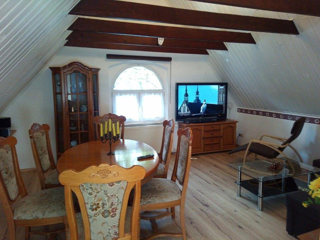 een eetkamer met een tafel en een tv bij FeWo Falke in Halberstadt