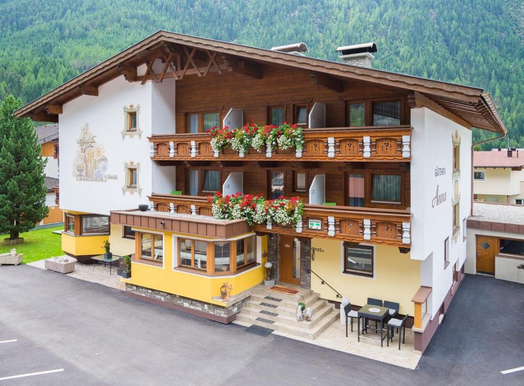 a house with flowers on the balconies of it at Gästeheim Anna in Längenfeld