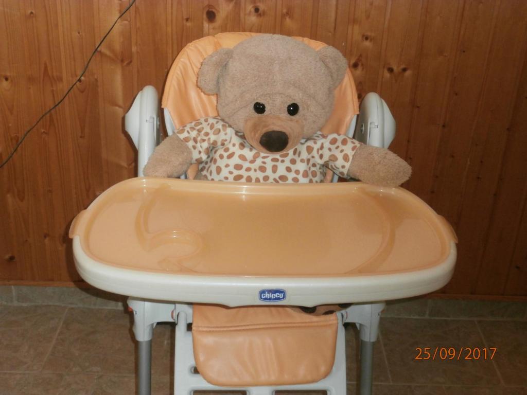 a stuffed teddy bear sitting in a high chair at Apartman Aya in Janov nad Nisou