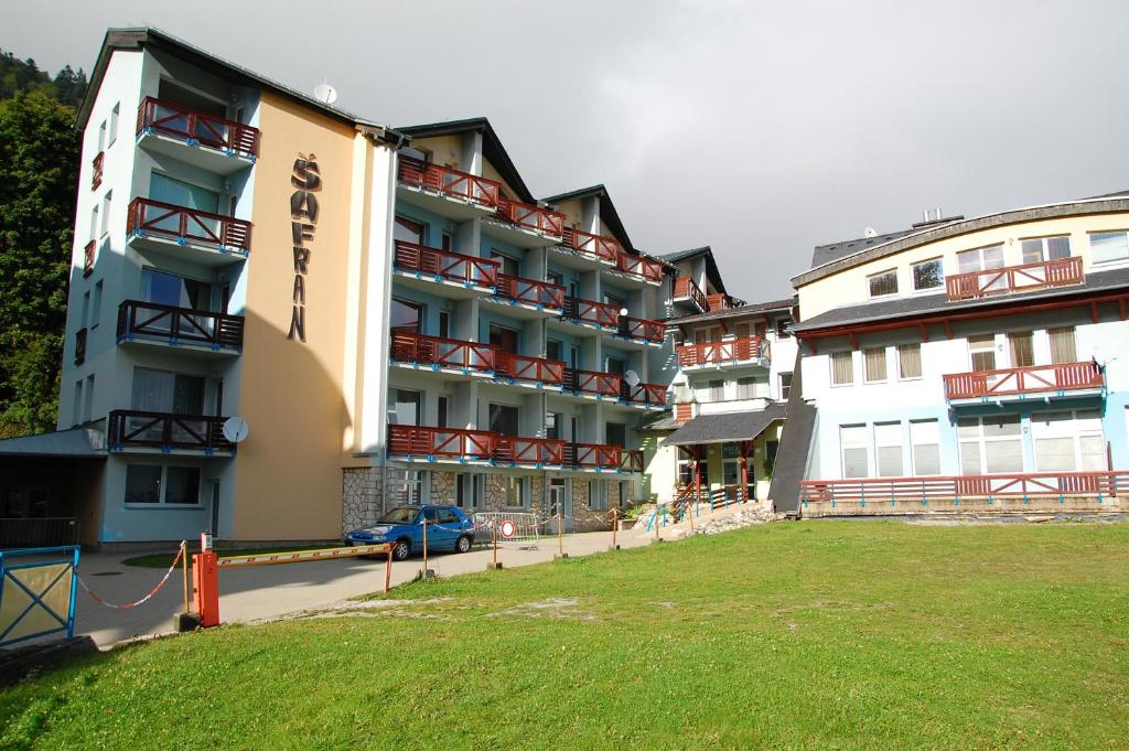 a large apartment building with a lawn in front of it at Apartmán Šafran in Donovaly