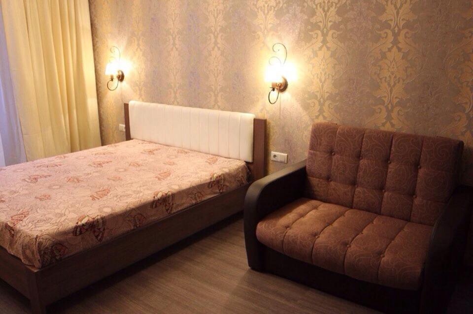 ヴォログダにあるApartments on Okruzhnoye shosse 26のベッドルーム(ベッド1台、ソファ付)