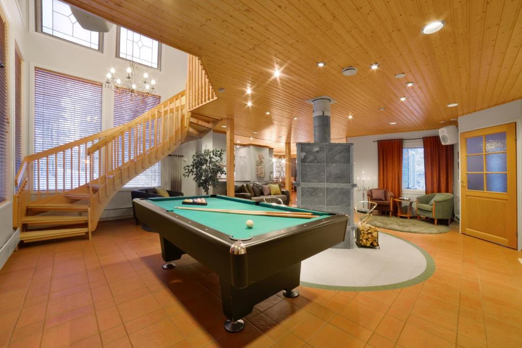 a living room with a pool table and a staircase at Vuokatin Aateli Villa Tsaari in Vuokatti