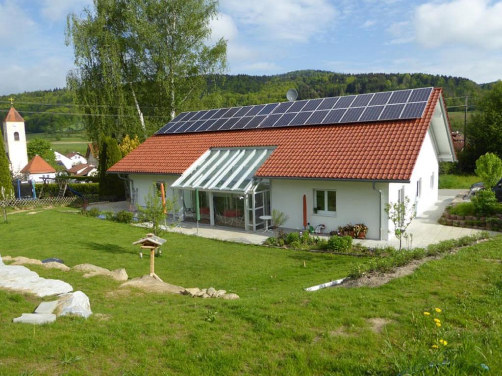 uma casa branca com painéis solares no telhado em Ferienhaus Geißdörfer em Hunding