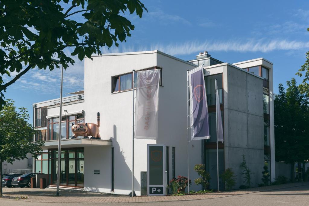 Un bâtiment blanc avec une statue à l'avant dans l'établissement Das Wildeck Hotel & Restaurant, à Abstatt