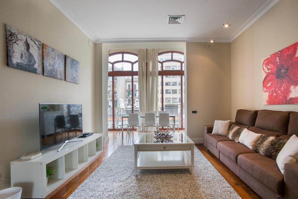 a living room with a couch and a tv at Tendency Rambla Catalunya in Barcelona