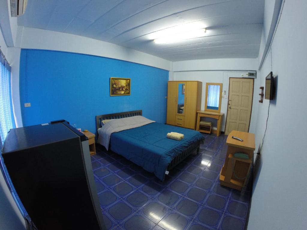 a blue bedroom with a bed and a television at Earth Mansion Sai 5 in Sam Phran