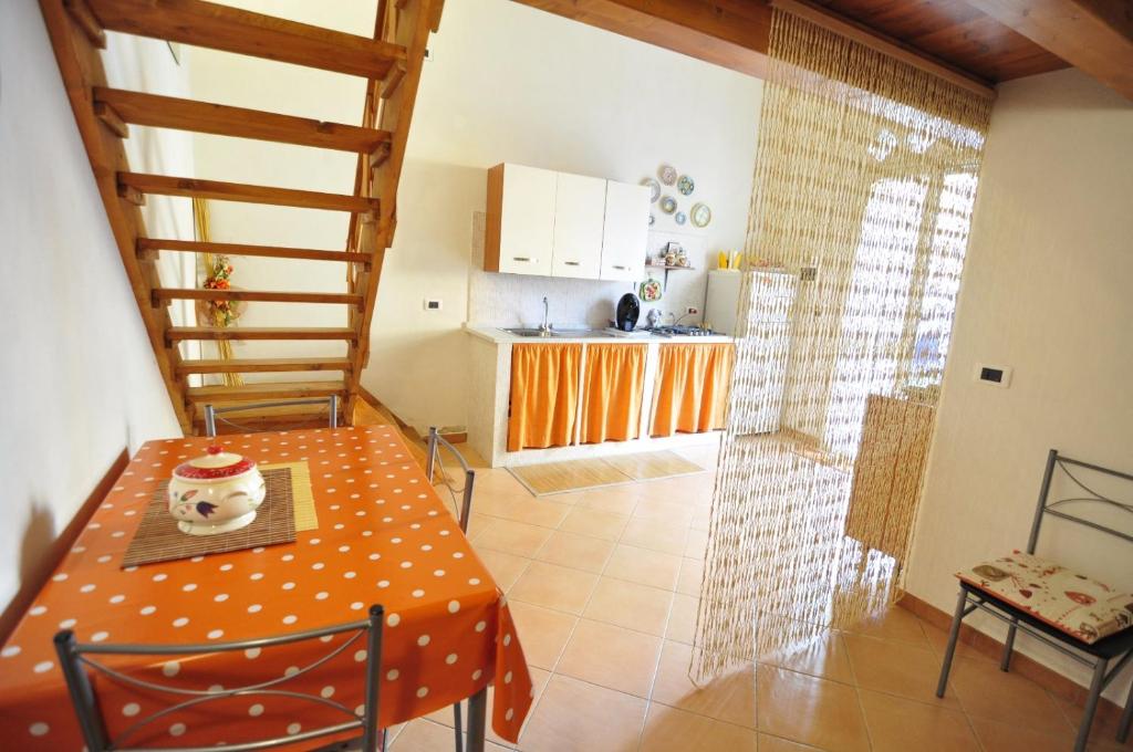 una cucina e una sala da pranzo con tavolo e scala di Case Vacanze Agrumi a Portopalo