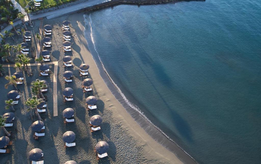 an overhead view of a group of cars parked on the beach at Amathus Beach Hotel Limassol in Limassol