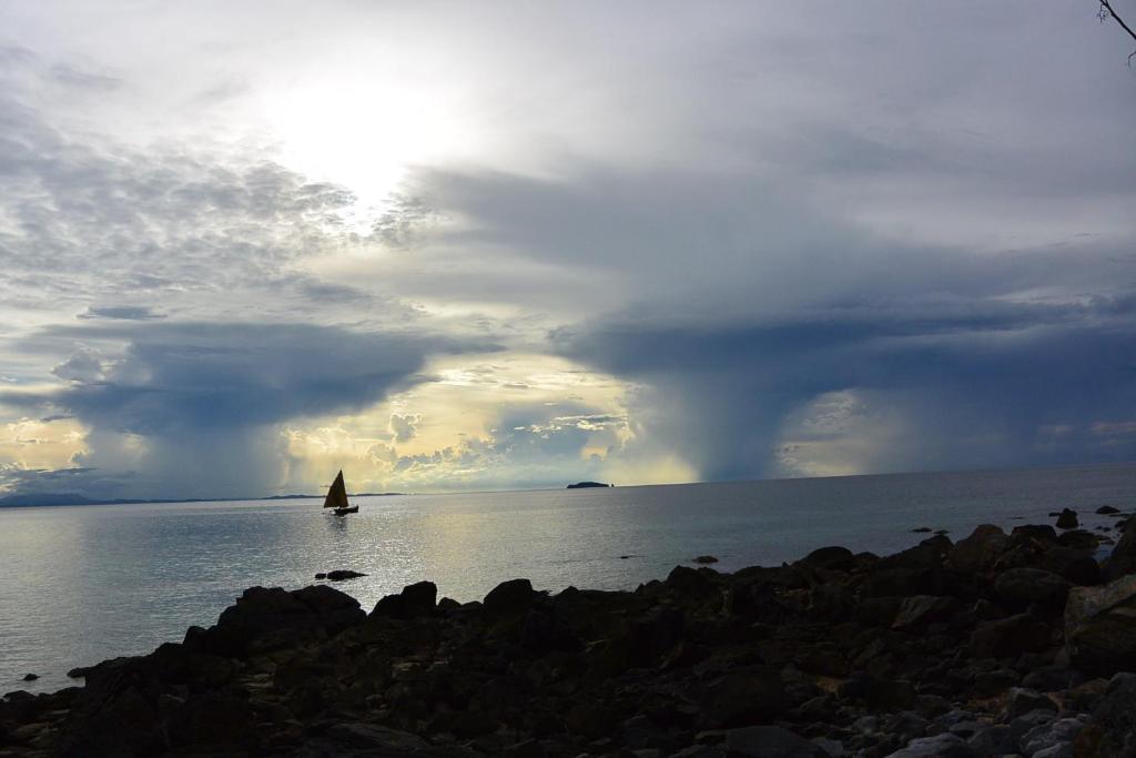 a boat in the water under a cloudy sky at Coco Komba Lodge in Nosy Komba