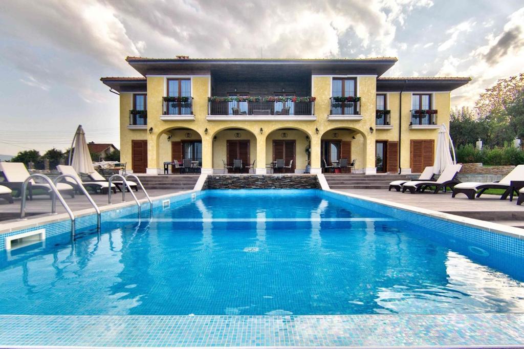 une maison avec une piscine en face d'une maison dans l'établissement Villa Del Sole, à Dobrevtsi