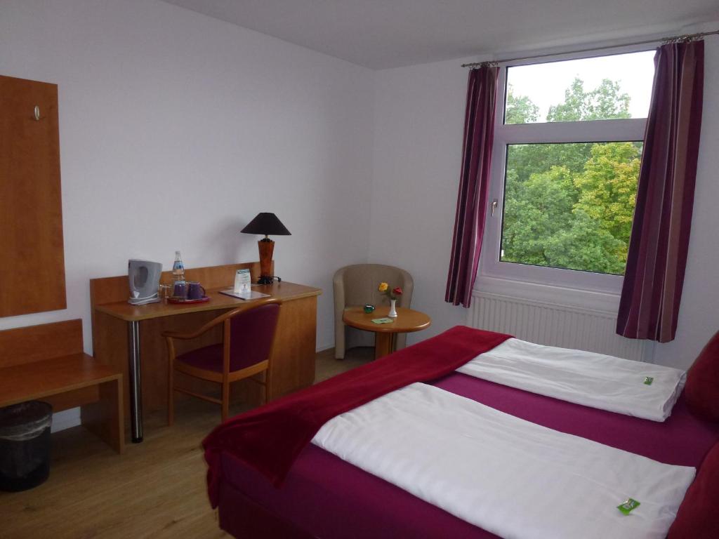 a bedroom with a bed and a desk and a window at Hotel Wildunger Hof mit Gemeinschaftsküche in Bad Wildungen