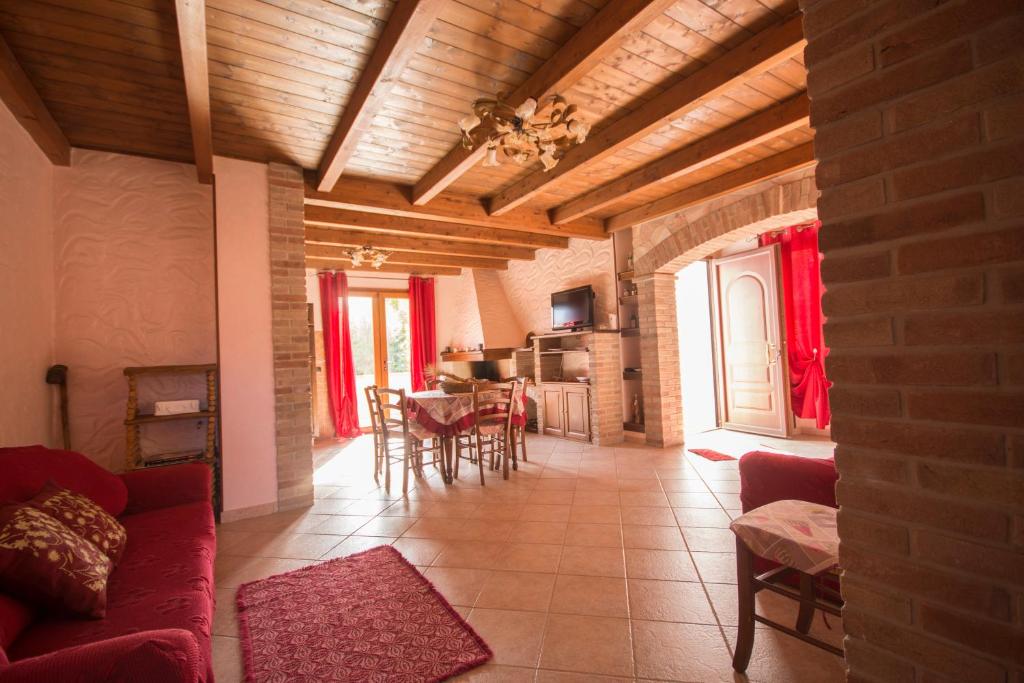 a living room with a red couch and a table at Casa Vacanza il Mandorlo in Domusnovas