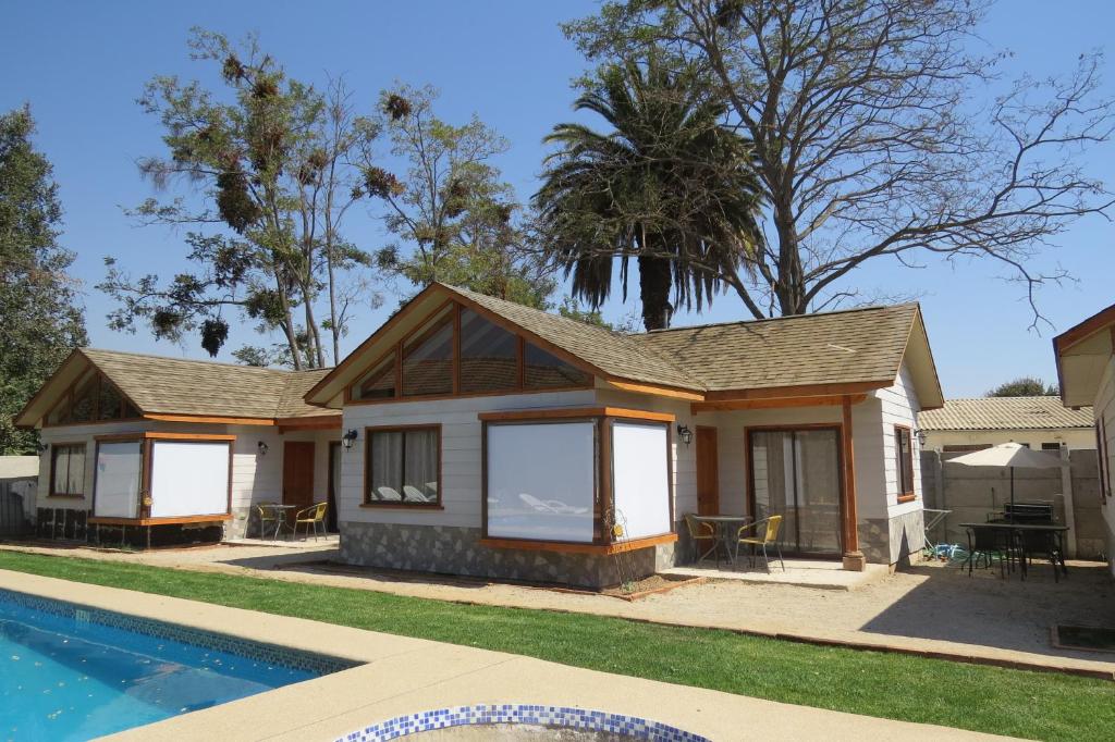 a house with a pool in front of it at Cabañas Vikurayen in Olmué