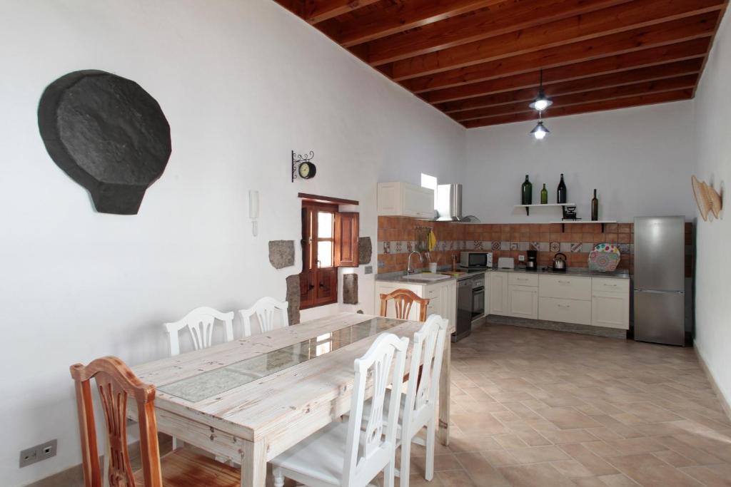 a large kitchen with a wooden table and chairs at CASERÍO LEANDRO I in Tías