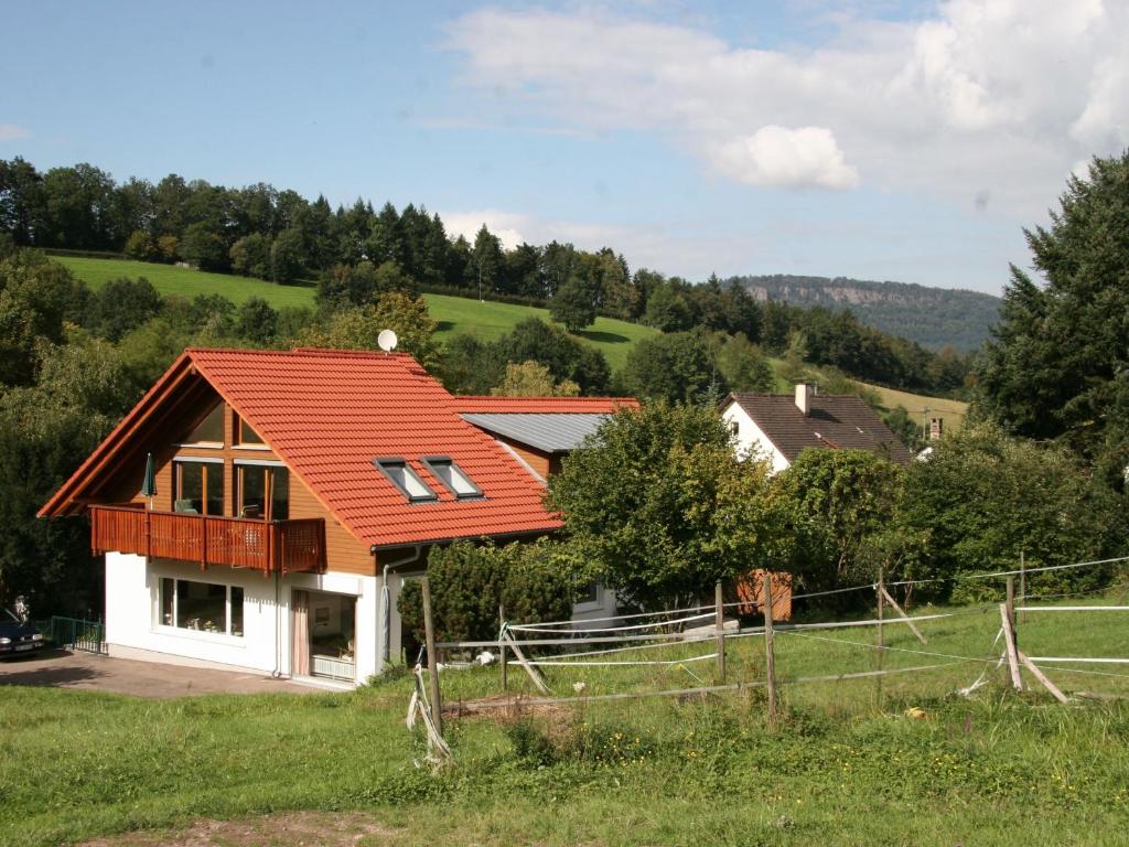 una casa con techo naranja en un campo verde en Haus am Gunzenbach en Baden-Baden