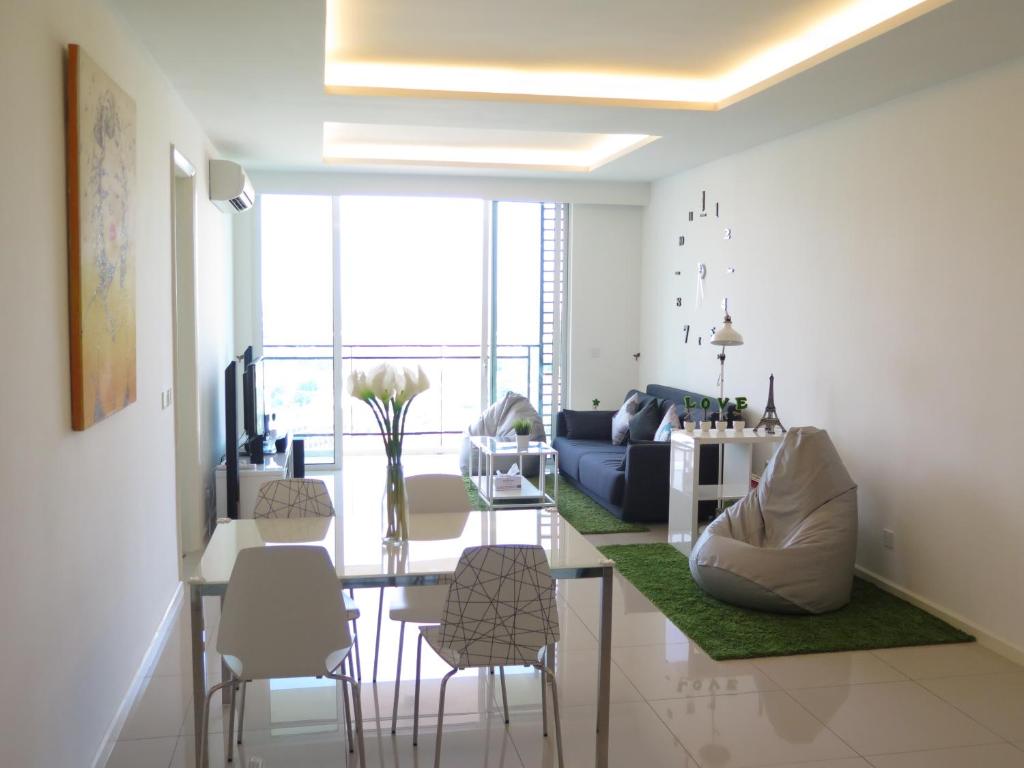Cozy Residence Melaka في ميلاكا: غرفة معيشة مع طاولة وبعض الكراسي