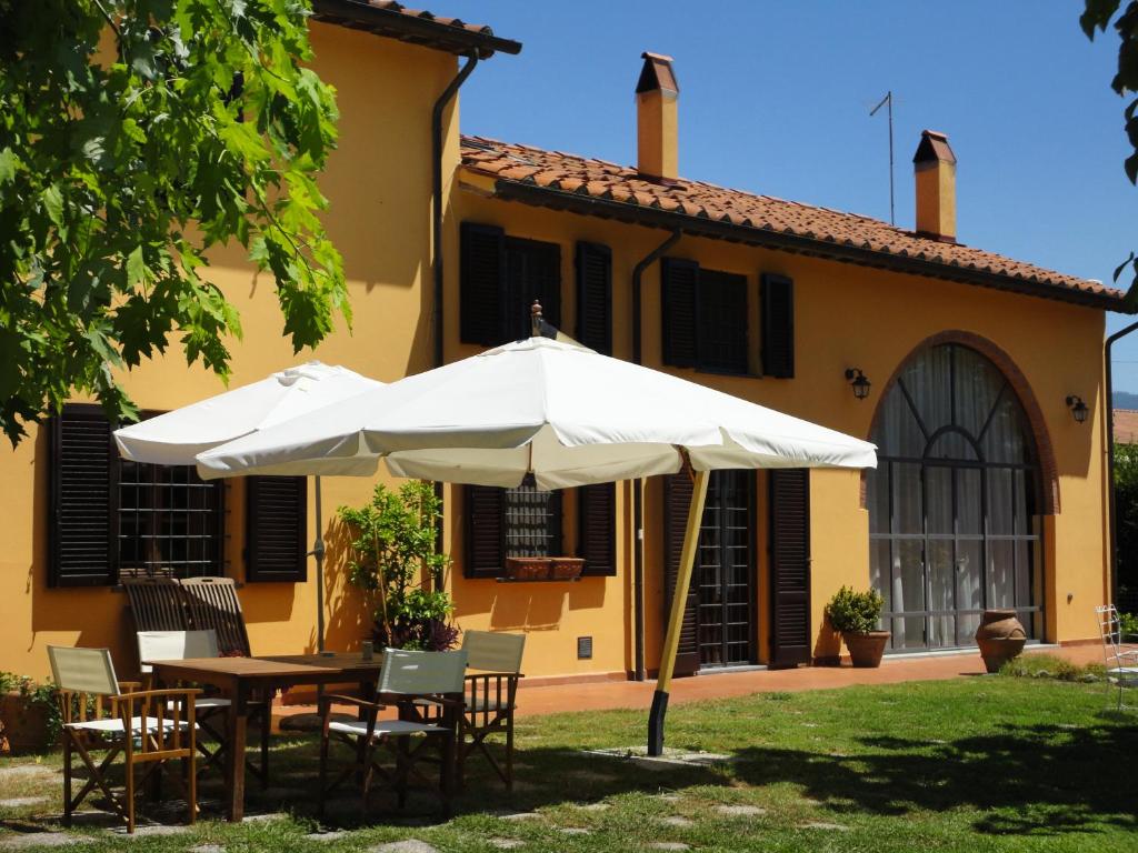 a table and umbrella in front of a house at Bed and breakfast Casa Formica in Cascina
