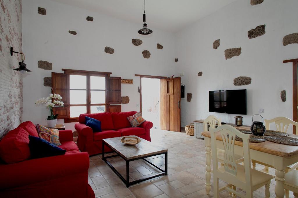 a living room with red couches and a table at Caserío Leandro III in Mácher